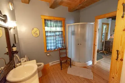 a bathroom with a shower and a toilet and a sink at Mirror Lakefront and SPA - A Fleur D'eau in Dudswell