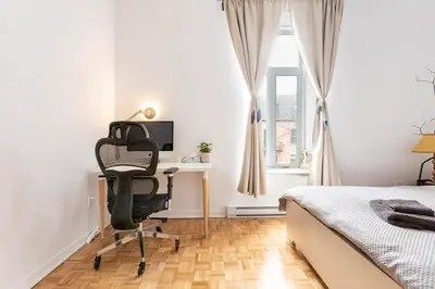 a bedroom with a desk and a chair next to a bed at 2 min from Bell Center, Downtown & metro station in Montréal