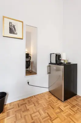 a kitchen with a refrigerator in a room with a mirror at 2 min from Bell Center, Downtown & metro station in Montréal