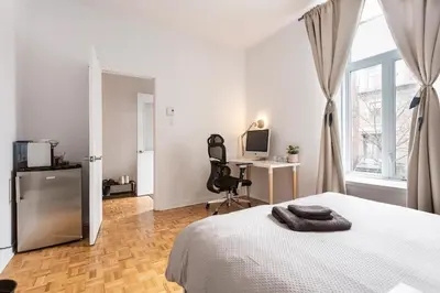 a bedroom with a bed and a desk and a window at 2 min from Bell Center, Downtown & metro station in Montréal
