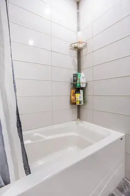 a white bath tub in a white tiled bathroom at 2 min from Bell Center, Downtown & metro station in Montréal