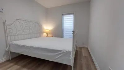 a bedroom with a white bed and a window at Bright 2BR Near River Private Parking in McMasterville