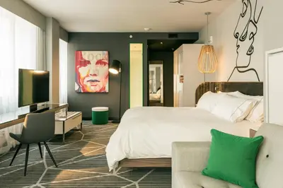 a bedroom with a bed and a tv and a couch at Renaissance Montreal Downtown Hotel in Montréal
