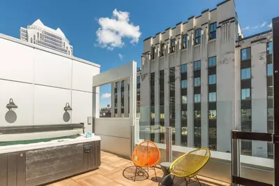 a balcony with two chairs and a tub on a building at Renaissance Montreal Downtown Hotel in Montréal