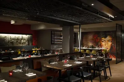 a restaurant with wooden tables and chairs and a large mural at Renaissance Montreal Downtown Hotel in Montréal