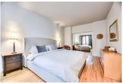 a bedroom with a bed and a dresser and a mirror at Condo lumineux au cœur du Mile-end in Montréal