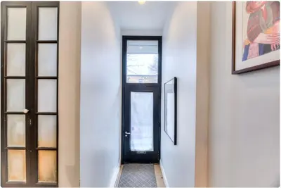 a hallway with a black door and two pictures on the wall at Condo lumineux au cœur du Mile-end in Montréal