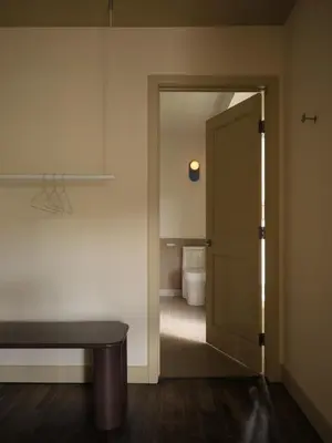 a bathroom with a door leading to a toilet at Pinôt Boutique Hôtel in Sutton