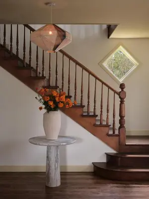 a vase of flowers on a table next to a staircase at Pinôt Boutique Hôtel in Sutton