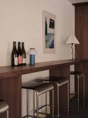a bar with three bottles of wine and two stools at Pinôt Boutique Hôtel in Sutton