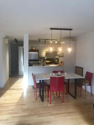 a dining room with a table and chairs and a kitchen at Lovely 2 bedroom in little burgandy in Montréal