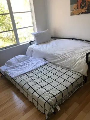 a bed sitting next to a window in a bedroom at Lovely 2 bedroom in little burgandy in Montréal
