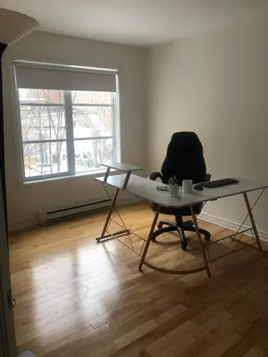 a desk and a chair in an empty room with a window at Lovely 2 bedroom in little burgandy in Montréal
