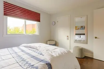 a white bedroom with a bed and a window at Cozy 2 bedroom close to downtown in Montréal