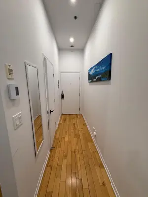 a hallway with white walls and a wooden floor at Charming Apartment downtown Montreal with Parking & Pet-Friendly in Montréal