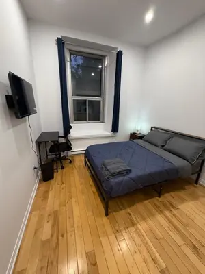 a bedroom with a bed and a desk and a window at Charming Apartment downtown Montreal with Parking & Pet-Friendly in Montréal