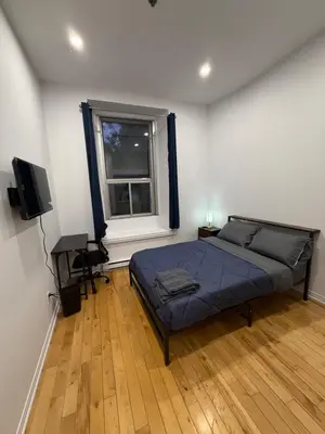 a bedroom with a bed and a desk and a window at Charming Apartment downtown Montreal with Parking & Pet-Friendly in Montréal