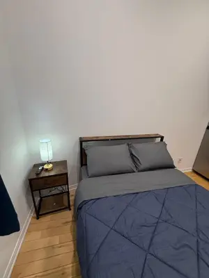a bedroom with a bed and a side table at Charming Apartment downtown Montreal with Parking & Pet-Friendly in Montréal