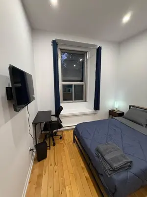 a bedroom with a bed and a desk and a window at Charming Apartment downtown Montreal with Parking & Pet-Friendly in Montréal