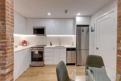 a kitchen with white cabinets and stainless steel appliances at Spacious 1BDR unit with Private Patio and Parking by M11 in Montréal
