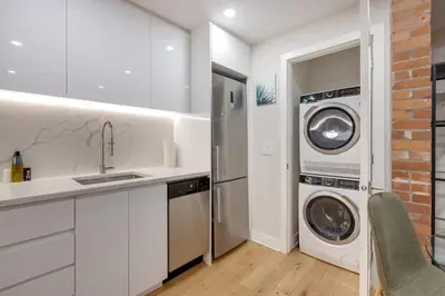 a white kitchen with a washer and dryer in it at Spacious 1BDR unit with Private Patio and Parking by M11 in Montréal