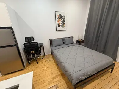 a bedroom with a bed and a television in it at Cozy studio with Parking near downtown in Montréal
