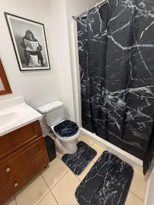 a bathroom with a black marble shower curtain and a toilet at Cozy studio with Parking near downtown in Montréal