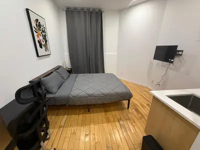 a bedroom with a bed in the corner of a room at Cozy studio with Parking near downtown in Montréal