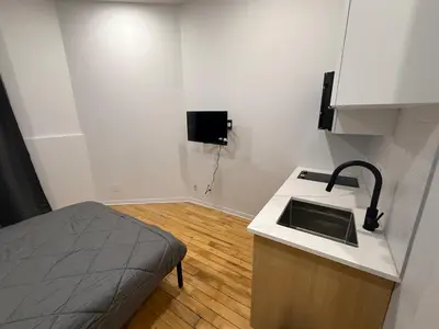 a kitchen with a sink and a bed in a room at Cozy studio with Parking near downtown in Montréal