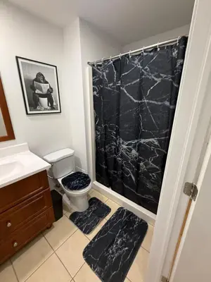 a bathroom with a black marble shower curtain and a toilet at Cozy studio with Parking near downtown in Montréal