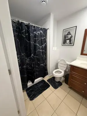 a bathroom with a black shower curtain and a toilet at 1 bedroom apartment near Montreal downtown with parking in Montréal