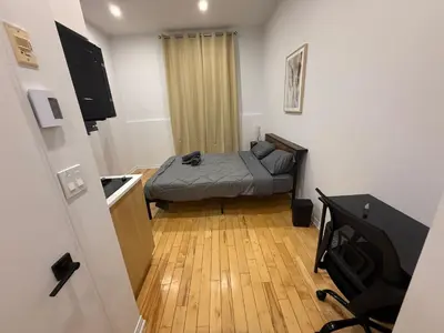a small bedroom with a bed and a kitchen at 1 bedroom apartment near Montreal downtown with parking in Montréal