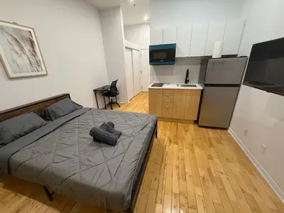 a small bedroom with a bed and a kitchen at 1 bedroom apartment near Montreal downtown with parking in Montréal