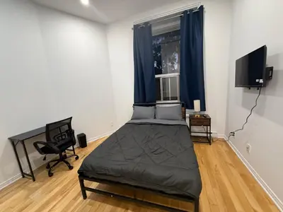 a bedroom with a bed and a window with blue curtains at Well located studio with Parking near Downtown Montreal in Montréal