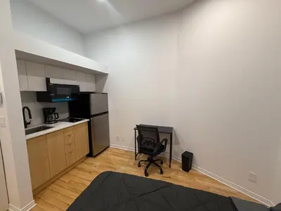 a kitchen with a black chair in a room at Well located studio with Parking near Downtown Montreal in Montréal