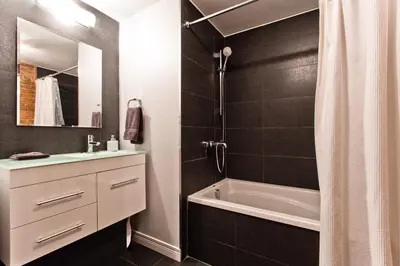 a bathroom with a tub and a sink and a shower at Le Old World Meets Modern in Montréal