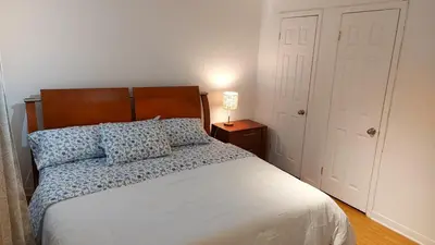 a bedroom with a bed and a lamp on a night stand at Spacious and comfortable accommodation in Longueuil
