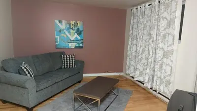a living room with a couch and a table at Spacious and comfortable accommodation in Longueuil
