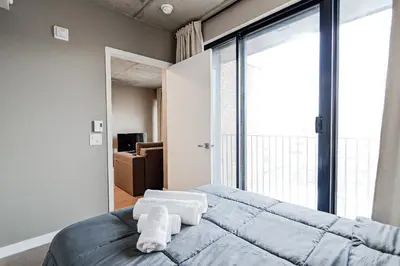a bedroom with a bed and a large window at Bright 1BR Apt with Convertible Armchair in Montréal