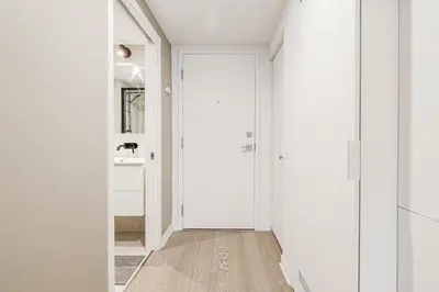 a hallway with white walls and a white door at Bright 1BR Apt with Convertible Armchair in Montréal
