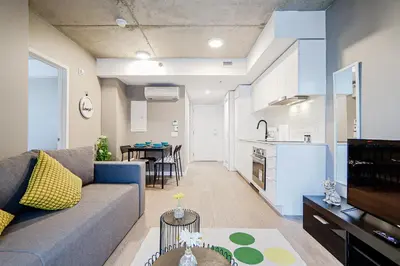 a living room with a couch and a kitchen at Bright 1BR Apt with Convertible Armchair in Montréal