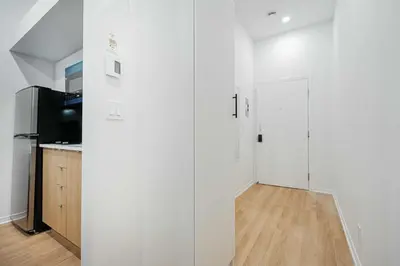 a white room with a kitchen and a refrigerator at Beautiful 3 person 2 Beds Studio with parking near downtown Montreal in Montréal
