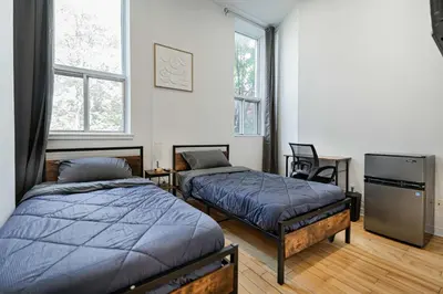 two beds in a room with two windows at Beautiful 3 person 2 Beds Studio with parking near downtown Montreal in Montréal