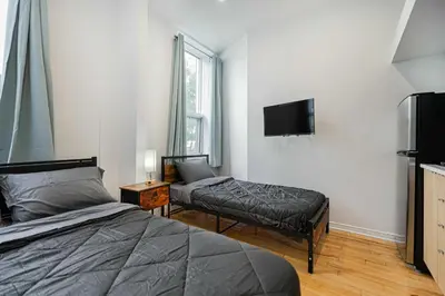 a bedroom with a bed and a flat screen tv at Beautiful 3 person 2 Beds Studio with parking near downtown Montreal in Montréal