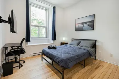 a bedroom with a bed and a desk and a chair at Beautiful 3 person 2 Beds Studio with parking near downtown Montreal in Montréal