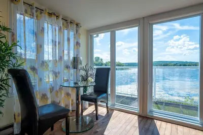 a room with a table and chairs and a large window at Spa & Lake Access - Le Chic Shack des 3 lacs in Trois-Lacs