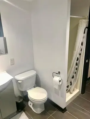 a bathroom with a toilet and a sink and a shower at Appartement au calme, à 15 min de Montréal in Longueuil