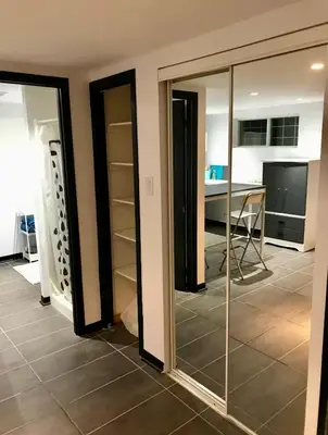 a room with glass doors and a room with a table at Appartement au calme, à 15 min de Montréal in Longueuil