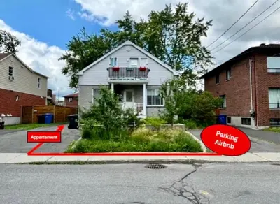 a house on the side of a street with two signs at Appartement au calme, à 15 min de Montréal in Longueuil