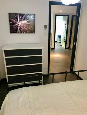 a bedroom with a bed and a dresser and a mirror at Appartement au calme, à 15 min de Montréal in Longueuil